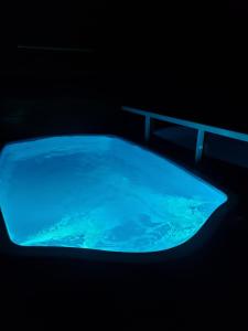 a large blue tub filled with water in a dark room at Apartamento com vista para piscina in Cataguases