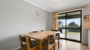 a dining room with a wooden table and chairs at 100 on Myer in Lakes Entrance