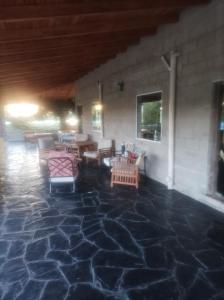 patio z krzesłami i stołami na kamiennej podłodze w obiekcie Posada el antiguo refugio w mieście Potrero de los Funes