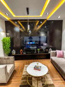 a living room with a couch and a tv at Chambre Deluxe in Cotonou