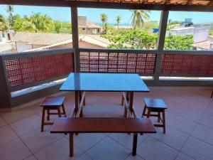una mesa azul y dos taburetes en un balcón en Condomínio das gaivotas en Alcobaça