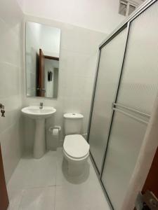 a white bathroom with a toilet and a sink at HOSTAL CASA PALMA in Ríohacha