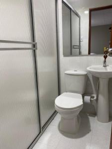 a bathroom with a toilet and a sink at HOSTAL CASA PALMA in Ríohacha