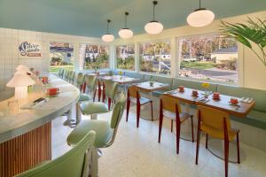 a dining room with tables and chairs and windows at Silver Sands Motel & Beach Bungalows in Greenport