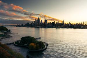 a view of a city from the water at sunset at W Hoboken in Hoboken