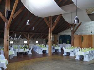 un salón de banquetes con mesas blancas y sillas blancas en Gasthuus Ulenhoff, en Westoverledingen