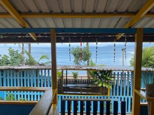 a view of the ocean from the porch of a beach house at Posada Brisas del Mar in Bahía Solano