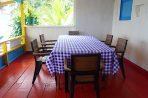 une table avec des chaises et un chiffon de table bleu et blanc dans l'établissement Posada Brisas del Mar, à Bahía Solano