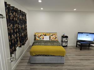a bedroom with a bed and a flat screen tv at A home in a room in Saint Mary Cray