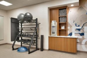 einen Fitnessraum mit einem Kleiderständer an Fitnessgeräten in einem Zimmer in der Unterkunft SpringHill Suites by Marriott Phoenix Scottsdale in Scottsdale