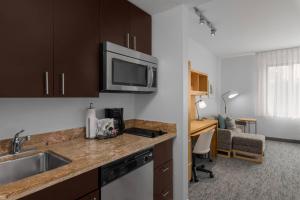 a kitchen with a sink and a desk in a room at TownPlaces Suite Denver Airport at Gateway Park in Aurora