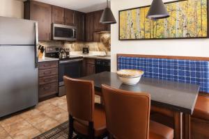 a kitchen with a table with chairs and a refrigerator at Marriott's Mountain Valley Lodge at Breckenridge in Breckenridge