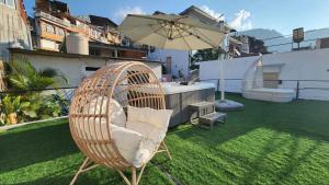 una silla de mimbre sentada en un césped con sombrilla en luxury atitlan suites en San Pedro La Laguna