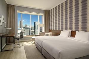 Schlafzimmer mit einem Bett, einem Schreibtisch und einem Fenster in der Unterkunft Rotterdam Marriott Hotel in Rotterdam