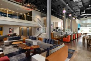 レドモンドにあるAloft Seattle Redmondのソファとテーブルのあるロビー、レストランを併設しています。