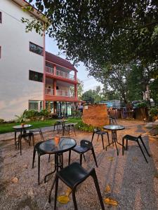 a group of tables and chairs in front of a building at Sabaidee Chiangmai Hotel SHA in Chiang Mai
