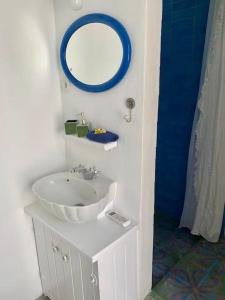 een badkamer met een wastafel en een spiegel aan de muur bij seasalthouse - famous tv location in Koskinou