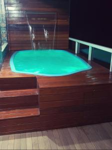 a bath tub with a green water in it at Apartamento com vista para piscina in Cataguases
