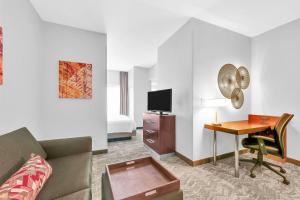 a living room with a couch and a desk with a television at SpringHill Suites by Marriott Tarrytown Westchester County in Tarrytown