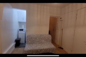 a small bedroom with a bed and a small refrigerator at Charmant appartement près de Montmartre in Paris