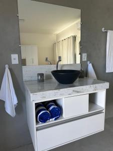 a bathroom with a counter with a sink and a mirror at Suíte aconchegante com delicioso café da manhã in Porto Seguro