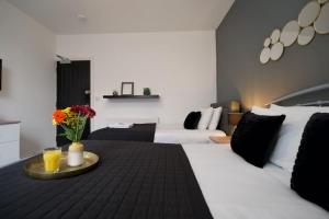 a hotel room with a table with flowers on it at Gordon House - 4Bed Coventry City Centre Oasis with Free Parking in Coventry