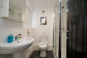 Baño blanco con lavabo y aseo en Gordon House - 4Bed Coventry City Centre Oasis with Free Parking en Coventry