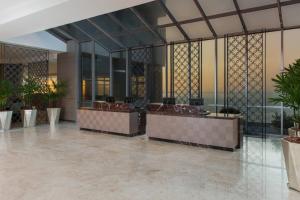 a lobby with a row of reception desks in a building at Sheraton Grand Rio Hotel & Resort in Rio de Janeiro