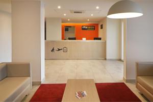 an office lobby with a waiting room and a table at City Express Junior by Marriott Tijuana Otay in Tijuana