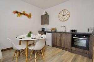 a kitchen with a white table and chairs and a sink at Matlock Studio 1 - Coventry in Coventry