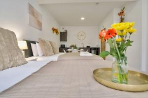 a room with a couch and a vase of flowers on a table at Matlock Studio 1 - Coventry in Coventry