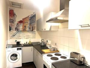 Two bed flat in popular York Rd في برمنغهام: مطبخ مع موقد وغسالة ملابس