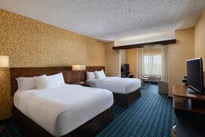 a hotel room with two beds and a television at Fairfield Inn & Suites by Marriott Lincoln Airport in Lincoln +13 photos