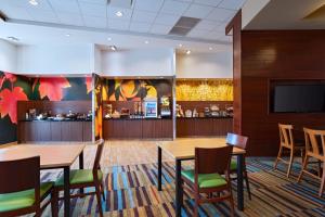 リンカーンにあるFairfield Inn & Suites by Marriott Lincoln Airportのテーブルと椅子のあるレストラン、バー