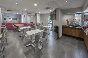 a restaurant with tables and chairs and a counter at City Express by Marriott Tampico in Tampico