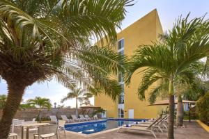 a resort with palm trees and a swimming pool at City Express by Marriott Tampico in Tampico