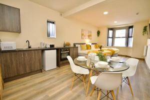 een keuken en een woonkamer met een tafel en stoelen bij Matlock Studio 2 – Coventry in Coventry