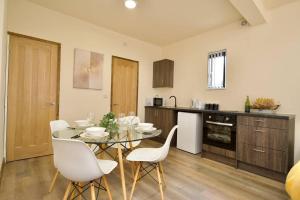 a kitchen with a glass table and white chairs at Matlock Studio 2 – Coventry in Coventry