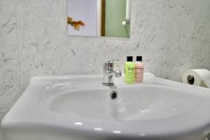a white bathroom sink with a bottle of soap on it at Matlock Studio 2 – Coventry in Coventry