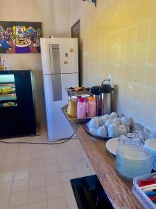 eine Küche mit einer Theke mit Tellern und einem Kühlschrank in der Unterkunft Pousada Atlântico Vista-Mar in João Pessoa