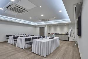 une salle de conférence avec des tables et des chaises ainsi qu'un podium dans l'établissement City Express Junior by Marriott Tuxtepec, à San Juan Bautista Tuxtepec