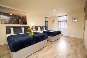 a bedroom with two beds and a table with flowers at Matlock Studio 4 - Coventry in Coventry