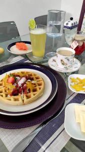 a table topped with a plate of waffles and drinks at Hotel Boutique Doña Maria in Ocaña
