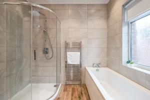 a bathroom with a bath tub and a shower at Cavehill View. An elegant 4 bedroom detached house. Your perfect Belfast retreat! in Belfast