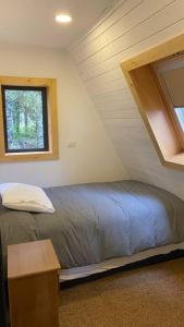 a bedroom with a bed and a window in a attic at Casa tipo A en laguna de trapen in Puerto Montt
