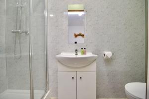 a white bathroom with a sink and a shower at Matlock Studio 5 - Coventry in Coventry