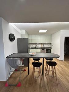 a dining room table with four chairs and a kitchen at Alojamento Cabeço de Vide in Cabeço de Vide