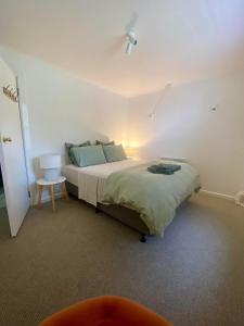 ein Schlafzimmer mit einem Bett, einem Tisch und einer Lampe in der Unterkunft JMP FLINDERS ACCOMODATION in Flinders