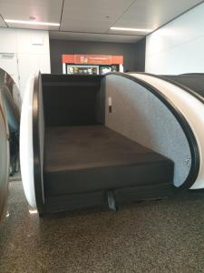 an empty seat in an airport baggage claim area at Sleeping Pods GoSleep - Inside of Warsaw Chopin Airport, non schengen restricted zone after passport control, near Gate 2N in Warsaw