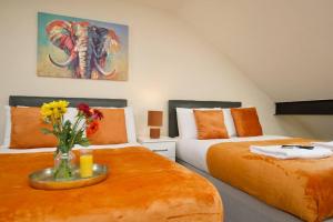 a bedroom with two beds and a vase of flowers at Matlock Studio 6 - Coventry in Coventry